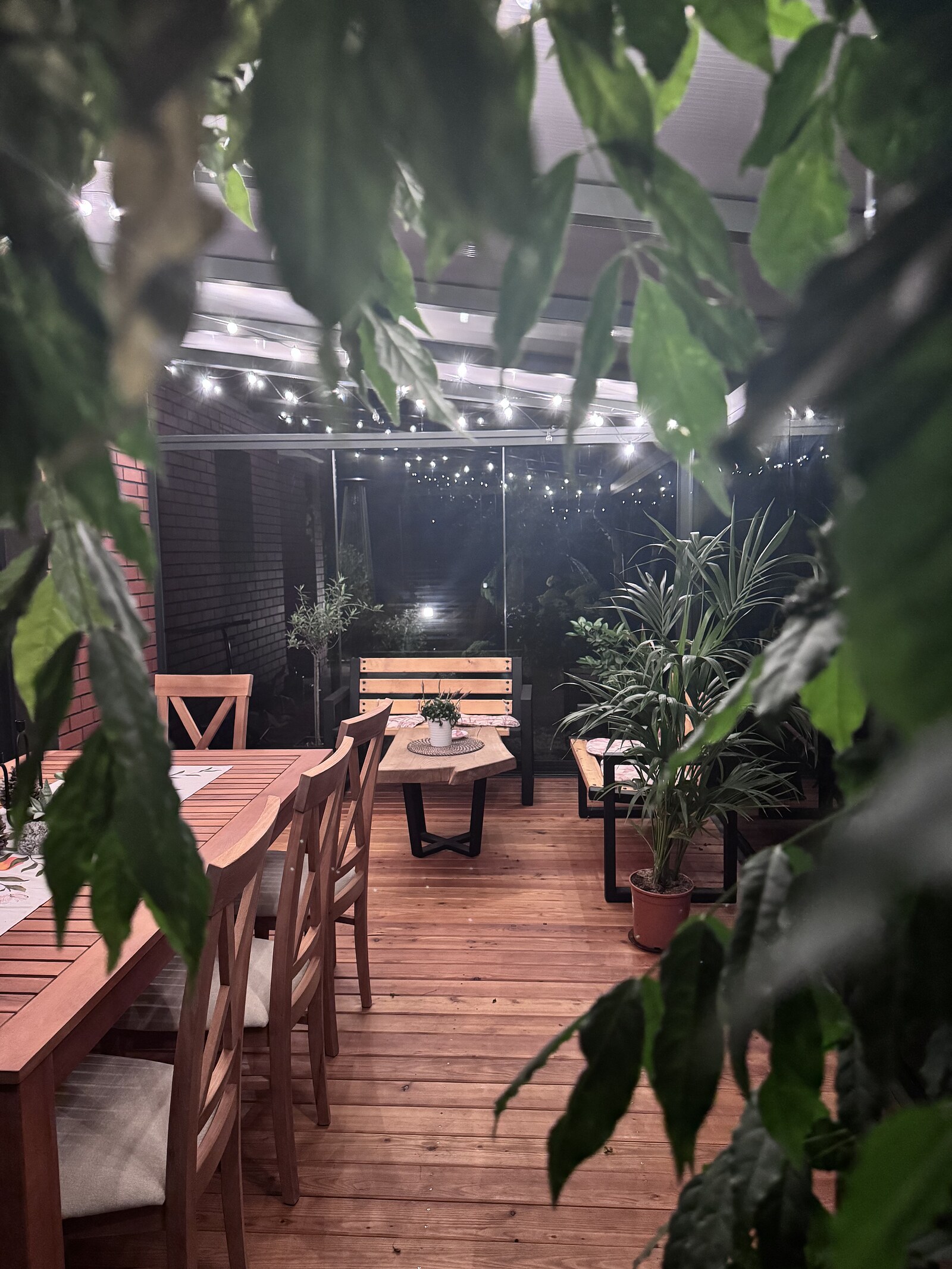 Wnętrze ogrodu zimowego — jasna strefa wypoczynku w przeszklonej altance, projekt Calm Design